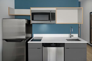 Cozinha moderna com geladeira de aço inoxidável, micro-ondas e lava-louças.