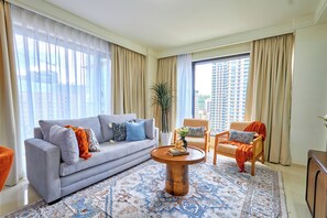 A modern living room with a grey sofa, a wooden coffee table, and a patterned rug. - 16th Floor Luxury -GTC Skyline Views with gym and workspace (Nairobi)