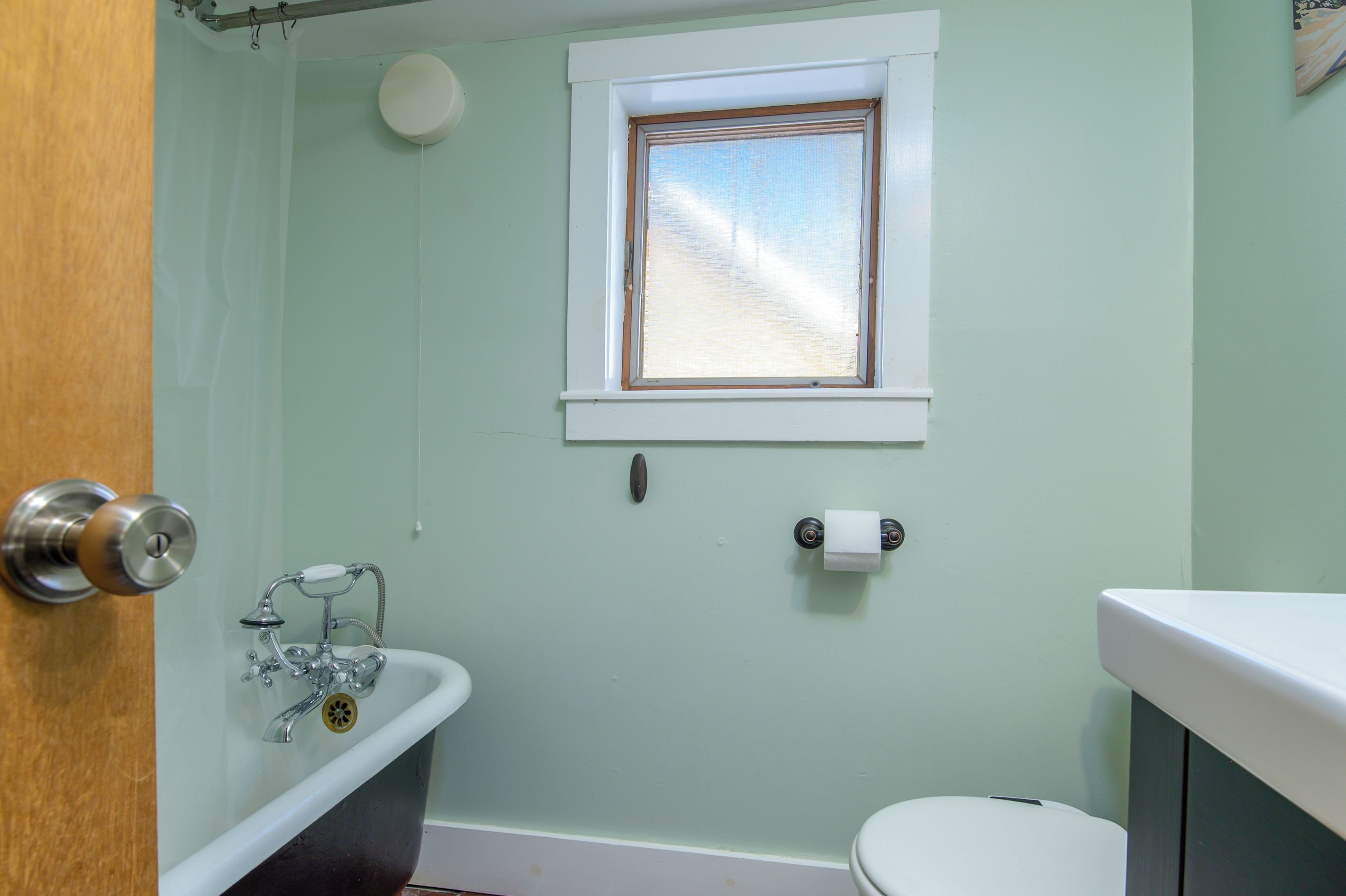 Ein Badezimmer mit Toilette, Waschbecken, Fenster und Dusche.