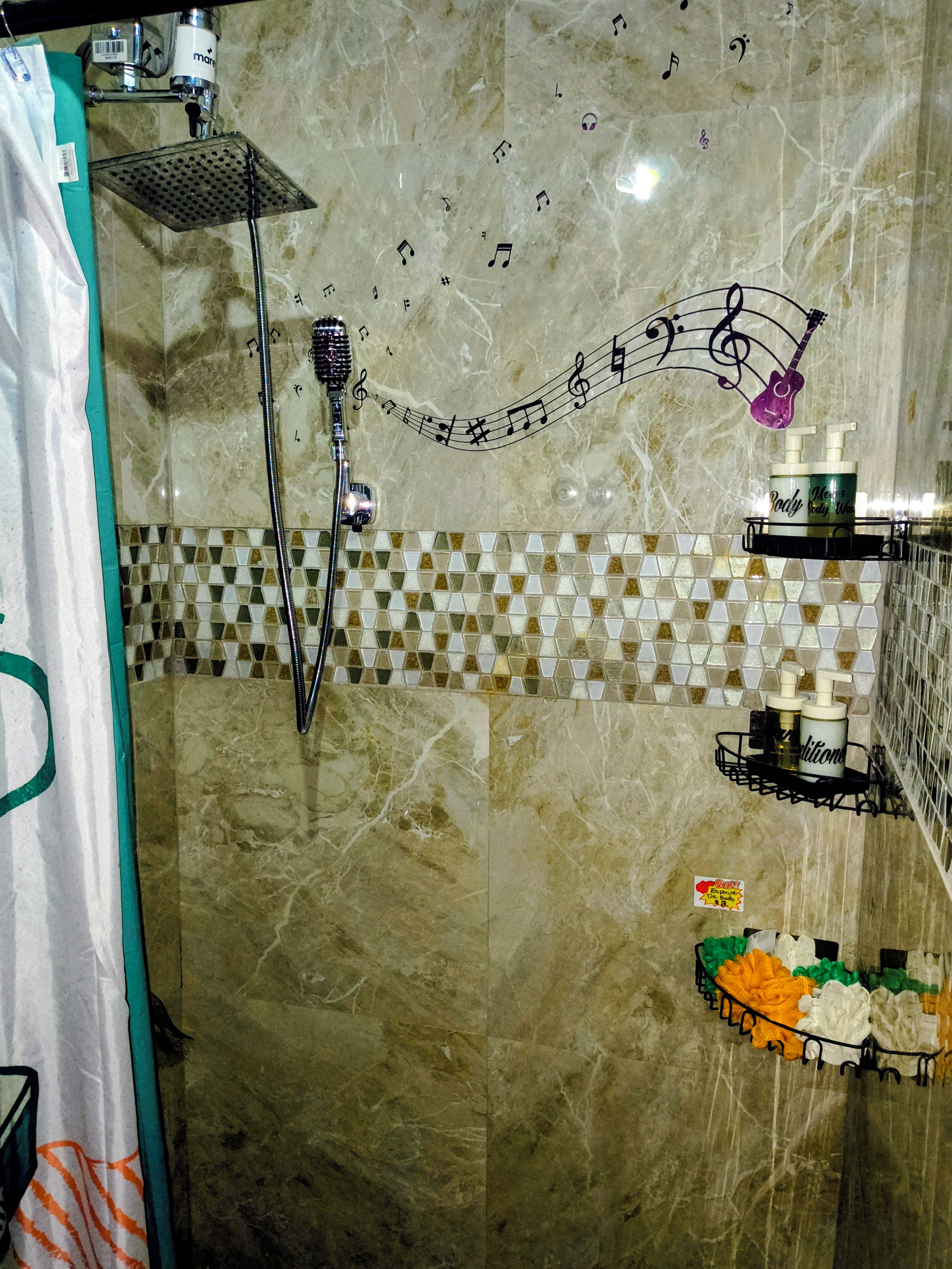 Een badkamer met een douche, een handdoekhouder, een zeepdispenser en een bordje met een 5-sterren beoordeling.