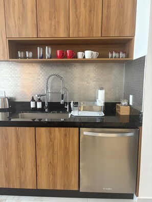 Een moderne keuken met houten kastjes, een roestvrijstalen spoelbak en een ingebouwde vaatwasser.
