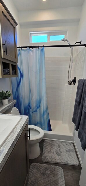 Ein Badezimmer mit Dusche, Toilette und Waschbecken.