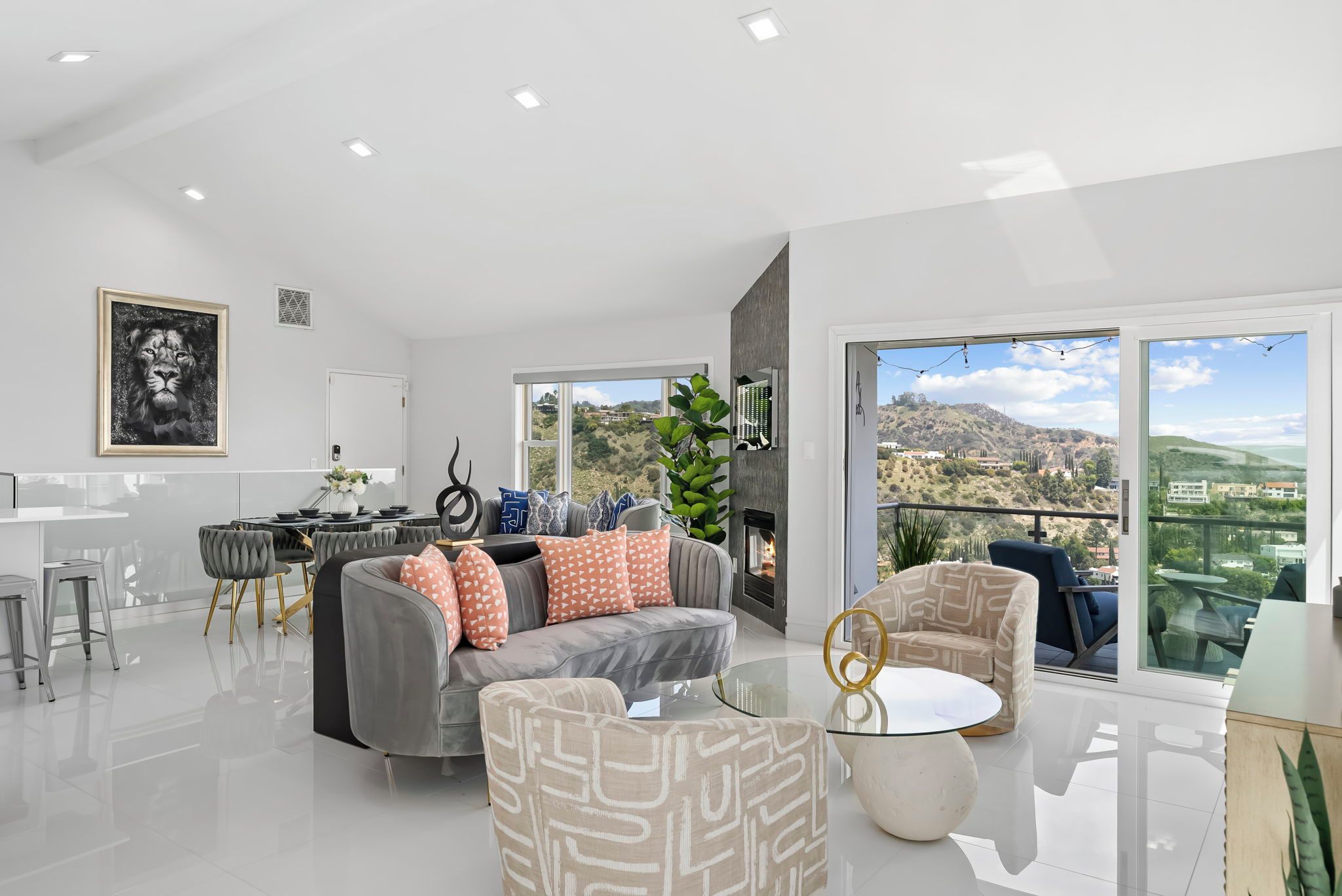 A modern living room with a grey sofa, patterned armchairs, and a glass coffee table.