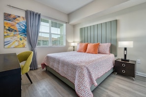 Ein modernes Schlafzimmer mit Bett, Nachttischlampen, Schreibtisch und Stuhl.