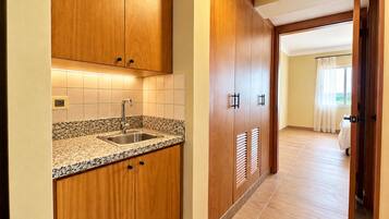 Una cocina con armarios de madera, encimera de granito y pileta de acero inoxidable.