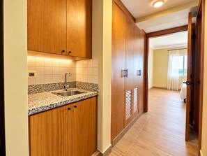 A kitchen with wooden cabinets, a granite countertop, and a stainless steel sink. - New Listing (Jarabacoa)
