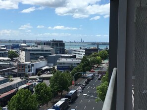Eine Stadtansicht mit modernen Gebäuden, einer belebten Straße und Blick aufs Wasser.