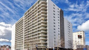Ein mehrstöckiges Hotel mit Balkonen, einem klaren Himmel und einer Ampel.