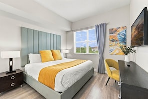 A modern bedroom with a bed, bedside tables, a desk, and a window with curtains. - Vista Cay 3BR Condo King Suite Near Universal (Orlando)