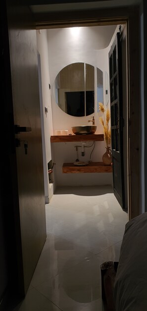 Une salle de bain équipée d’un lavabo, d’un miroir et d’un porte-serviettes.