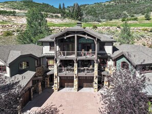 A multi-story building with a central courtyard, stone pillars, and a balcony with outdoor seating. - Walk to Frostwood Gondola, private hot tub (Park City)