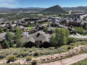 A residential area with multiple houses, a mountain in the background, and a clear sky. - Walk to Frostwood Gondola, private hot tub (Park City)