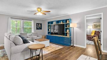Sit at the round table with the TV wall behind you.