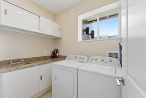A laundry area with a washer and dryer, a sink, and a window. - 3 Suites Near Disney Patio Grill & Balcony (Kissimmee)