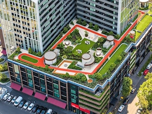 A modern building with a rooftop garden, multiple floors, and a parking area. - Resort-Style 2BR Living with Pool, Gym and Sauna (South Melbourne)