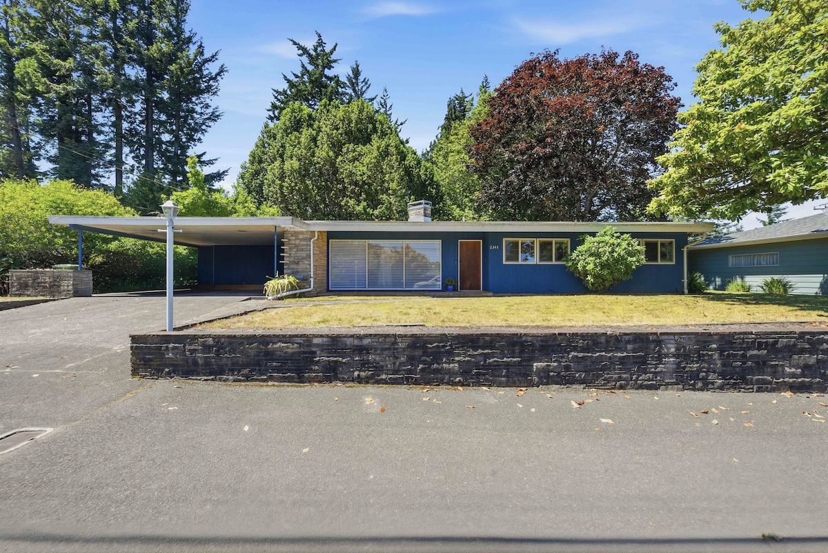 A modern two-story house with a garage, a covered patio, and a well-maintained lawn.