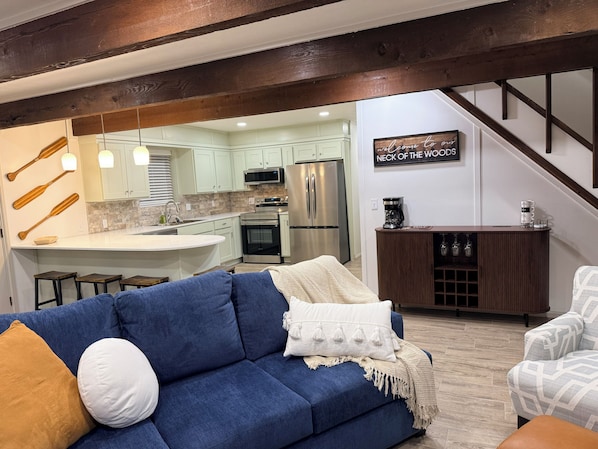 Una cocina moderna con una isla central, electrodomésticos de acero inoxidable y techo de madera.