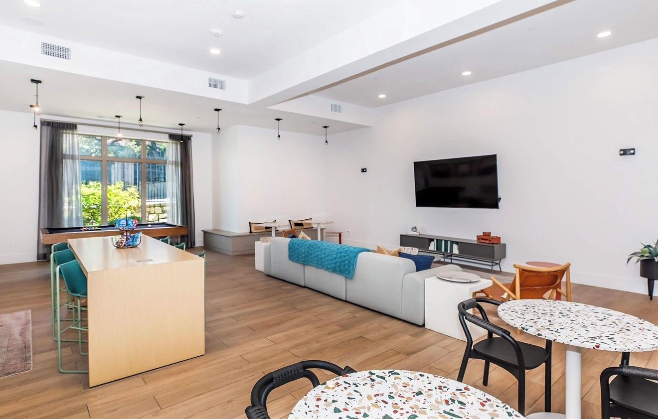A modern living room with a sofa, coffee table, and dining area.