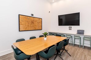 Una sala conferenze con una grande mappa, un televisore a schermo piatto e una stampante.