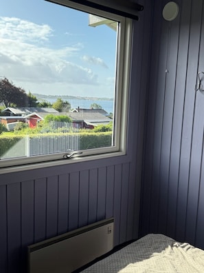 A room with a window overlooking a residential area and a body of water. - Holiday home with sea views near the beach (Egernsund)
