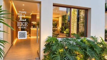 A hotel lobby with a modern design, a reception desk, and a QR code for digital access.
