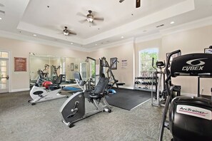 A gym with cardio machines, weightlifting equipment, and a mirror wall. - Poolside Stay | Private Balcony | Near Disney (Davenport)