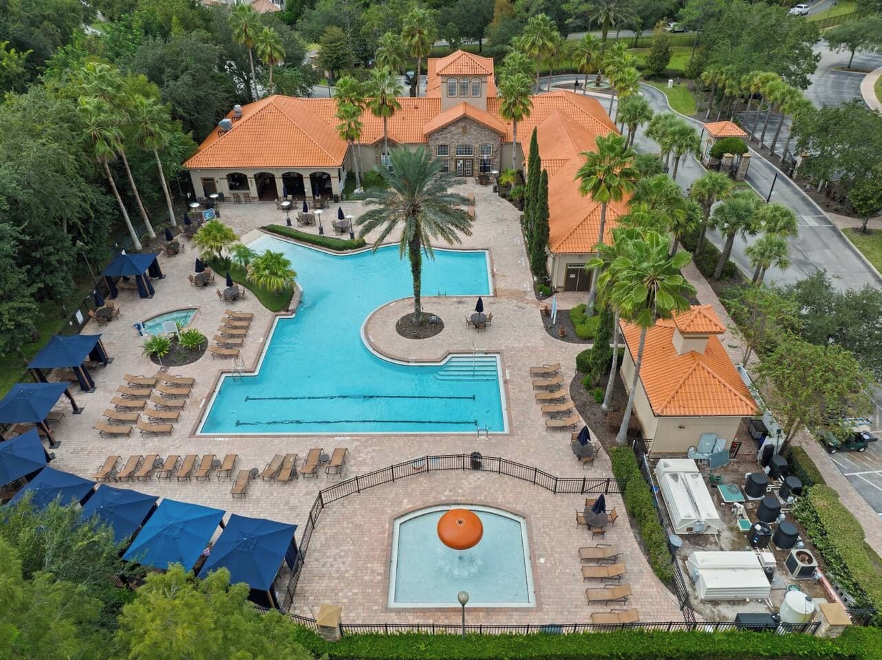 Ein Resort mit großem Schwimmbad, Liegebereichen und einem angelegten Garten.