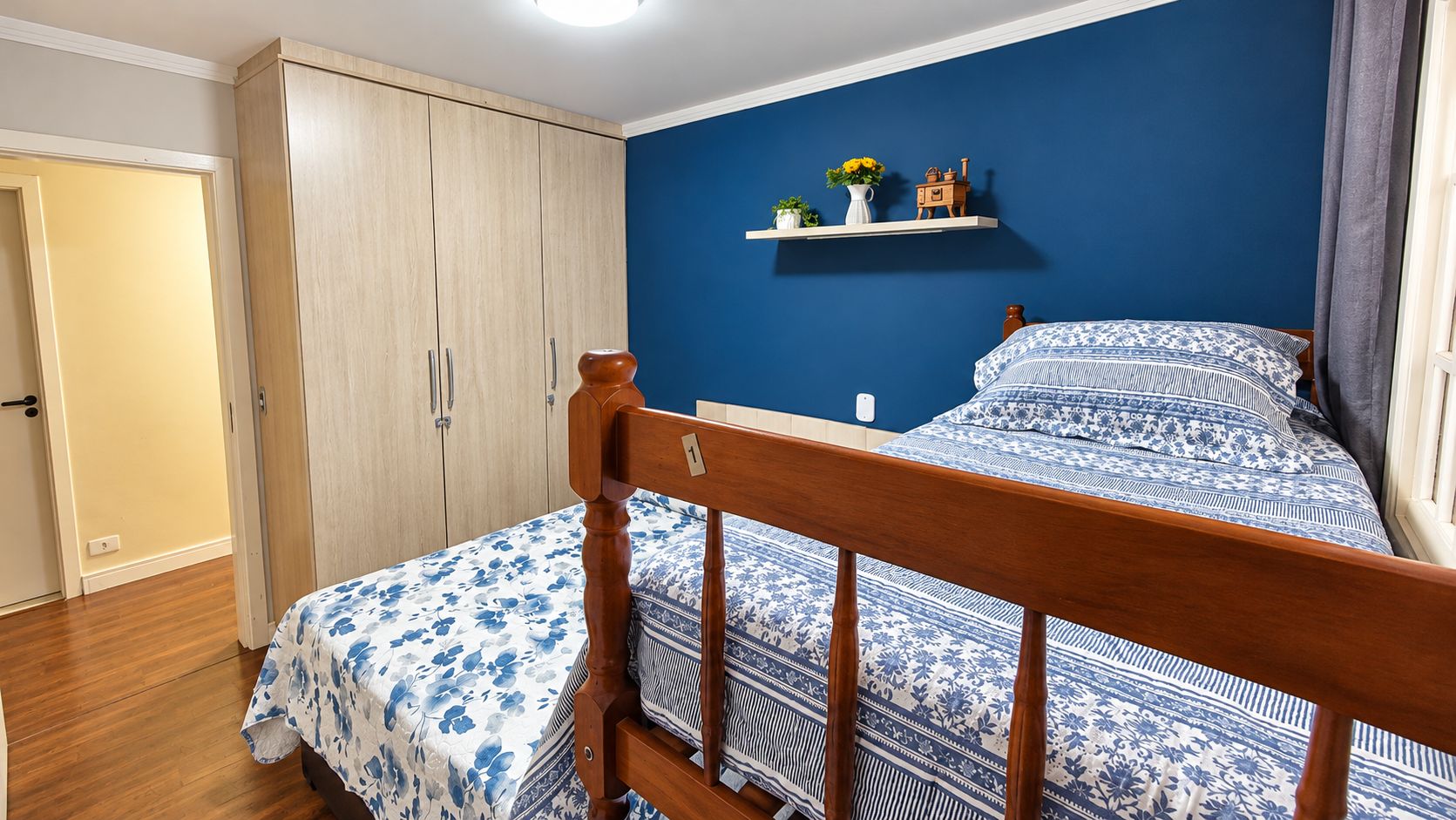 Ein Schlafzimmer mit einem hölzernen Bett, einem Kleiderschrank und einem Regal mit Dekorationsgegenständen.