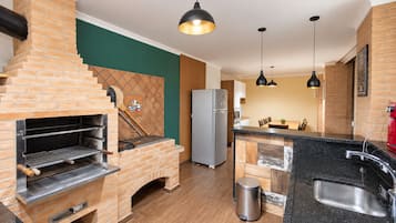Une cuisine dotée d’un four en briques, d’appareils électroménagers en acier inoxydable et d’un design moderne.