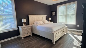 Een slaapkamer met een bed, nachtkastjes en een raam.
