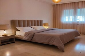 Un dormitorio con una cama, mesitas de noche y una lámpara.
