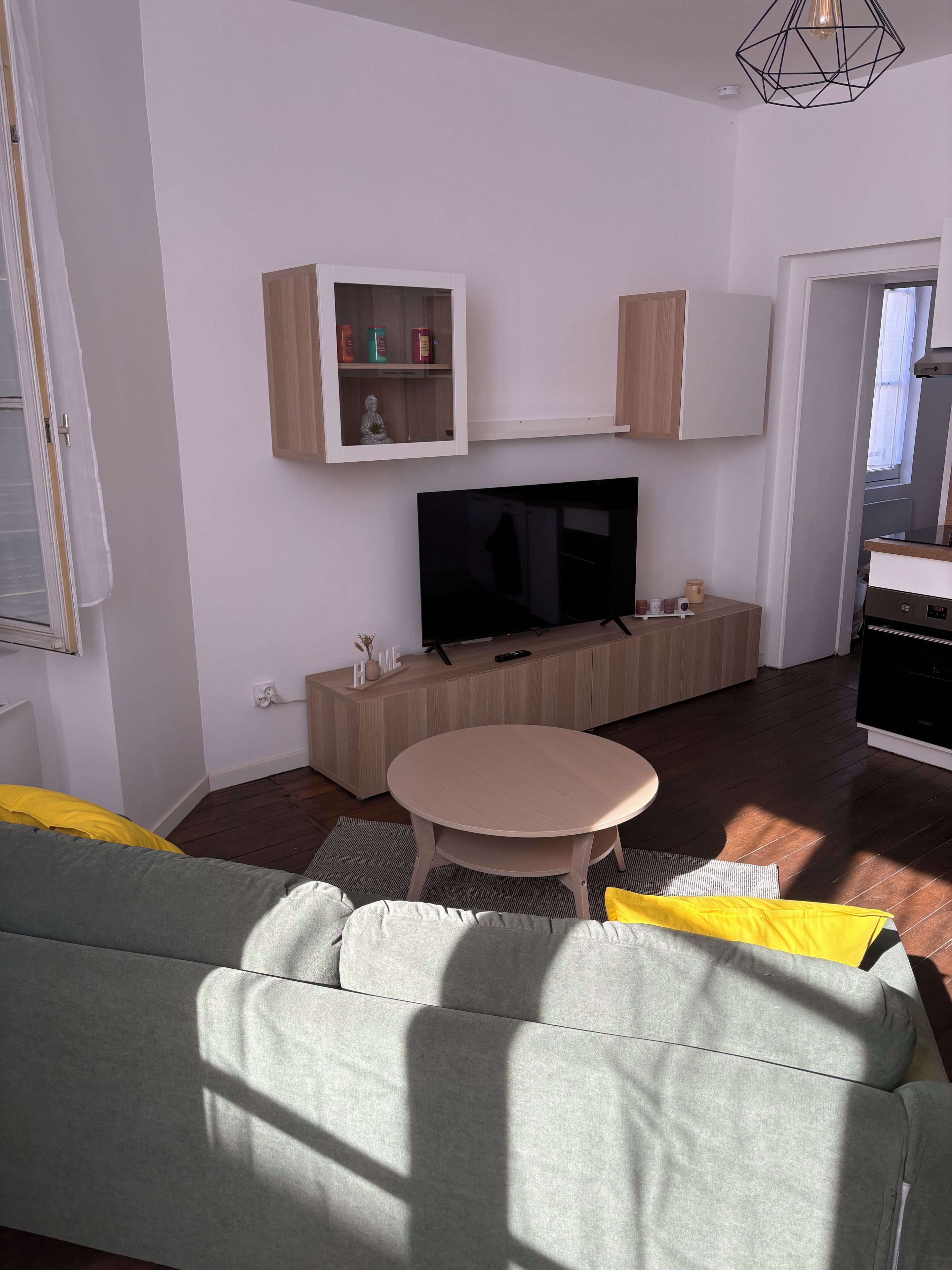 Un soggiorno con divano, televisore, mobile e zona pranzo.