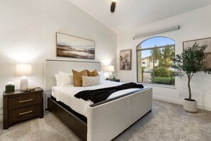 A bedroom with a bed, nightstands, a large window, and artwork. - NEW|The Beaumont @ Bainbridge|Heated Pool|FirePit (Fountain Hills)