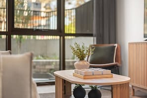 Un salon moderne avec une table ronde en bois, une plante en pot et un jeu de société.