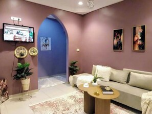 Een moderne woonkamer met een bank, salontafel en kunstwerken aan de wanden.