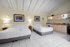 A hotel room with two beds, a kitchenette, and a ceiling with exposed beams. - SunnyStay Villa - A Spacious 5-Bedroom Villa with Pool & Mini Golf (Moko)