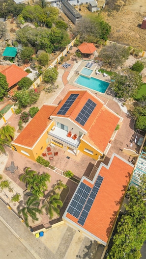 A residential complex with multiple buildings, solar panels, swimming pools, and a patio area. - SunnyStay Villa - A Spacious 5-Bedroom Villa with Pool & Mini Golf (Moko)