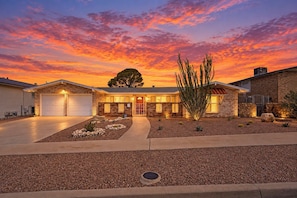 A two-story house with a garage, a landscaped front yard with rocks and cacti, and a tree. - El Paso Desert Oasis (El Paso)
