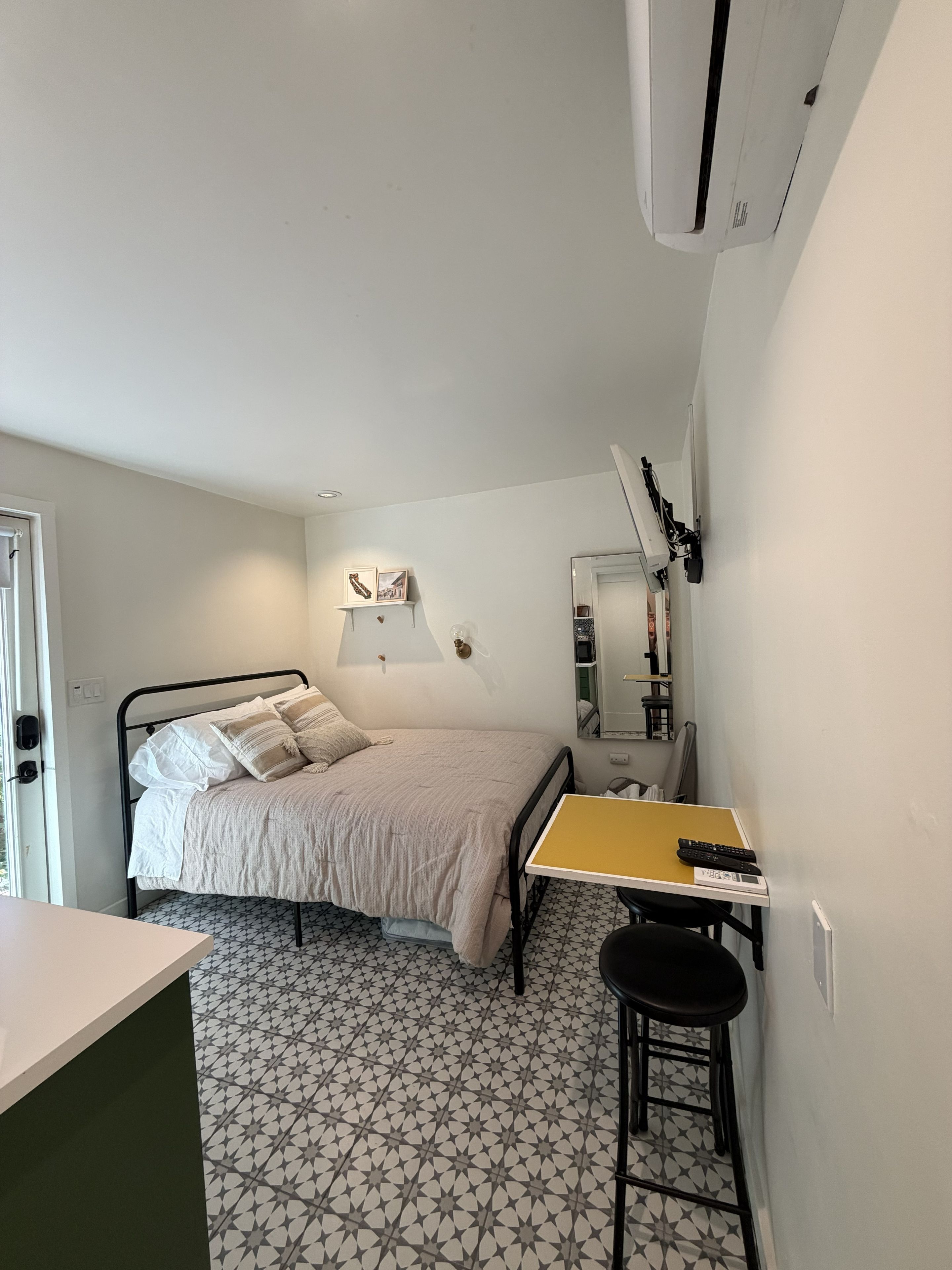 Una habitación pequeña con cama, escritorio y silla.