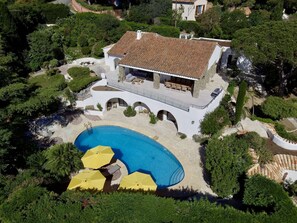 A large house with a swimming pool, outdoor seating, and a stone pathway. - VILLA NEAR THE BEACH WITH SWIMMING POOL AND LOVELY SEA VIEWS TO RENT FOR 10 PEOPLE (STE MAXIME)