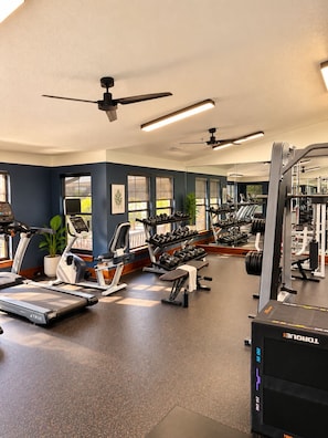 Ein Fitnessstudio mit Laufbändern, Kurzhanteln und Kraftgeräten.