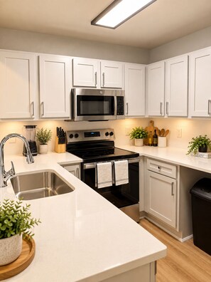 A modern kitchen with white cabinetry, stainless steel appliances, and a wooden countertop. - The Saturday Social w/ Shuttle and Amenities! (Athens)