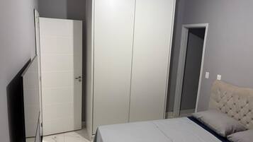 A bedroom with a bed, a wardrobe, and a door.