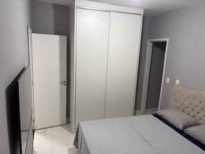 Un dormitorio con cama, armario y puerta.