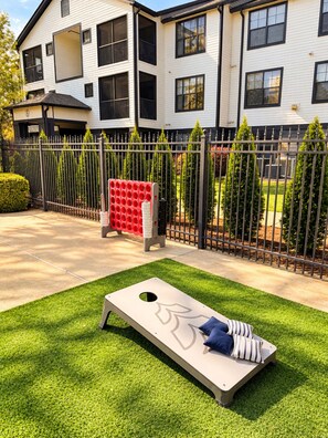 A residential area with a flat lawn, a metal fence, and a building with multiple windows and balconies. - The Athens All-Star w/ Free Shuttle (Athens)