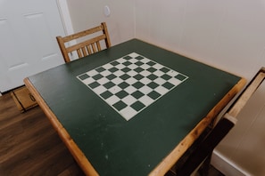 A room with a checkered table, a wooden chair, and a white door. - Wonderful 2-bedroom cabin in Big Bear for a relaxing getaway (Big Bear)