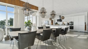 A modern kitchen with white cabinets, a central island, and stainless steel appliances. - VillaVilla 1022 - Ebeltoft, Østjylland (Ebeltoft)