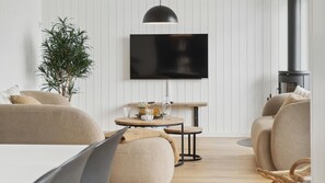 A modern living room with a sofa set, a coffee table, a TV mounted on the wall, and a potted plant. - VillaVilla 1015 - Hvide Sande, Vestjylland (Hvide Sande)