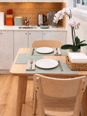 A dining area with a table set for two, a kettle, and a potted orchid. - Private Toronto Suite | Free Parking • Near Airport & Downtown (Toronto)