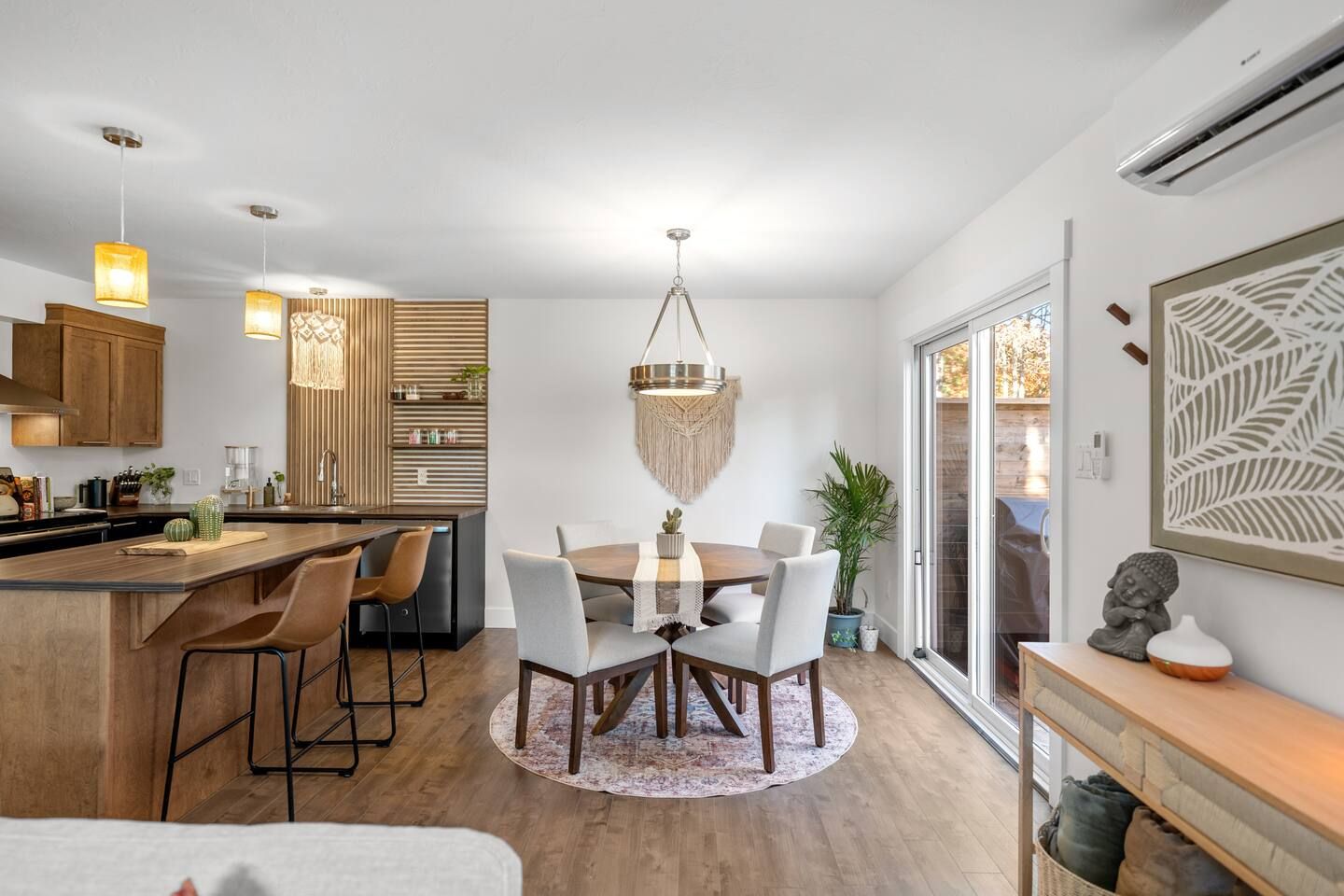 A modern kitchen with a central island, bar stools, and pendant lighting.
